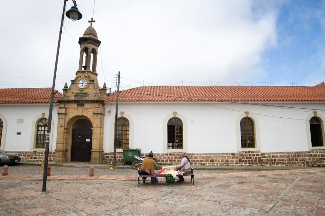 Public plaza with benches and people resting in a Latin American city