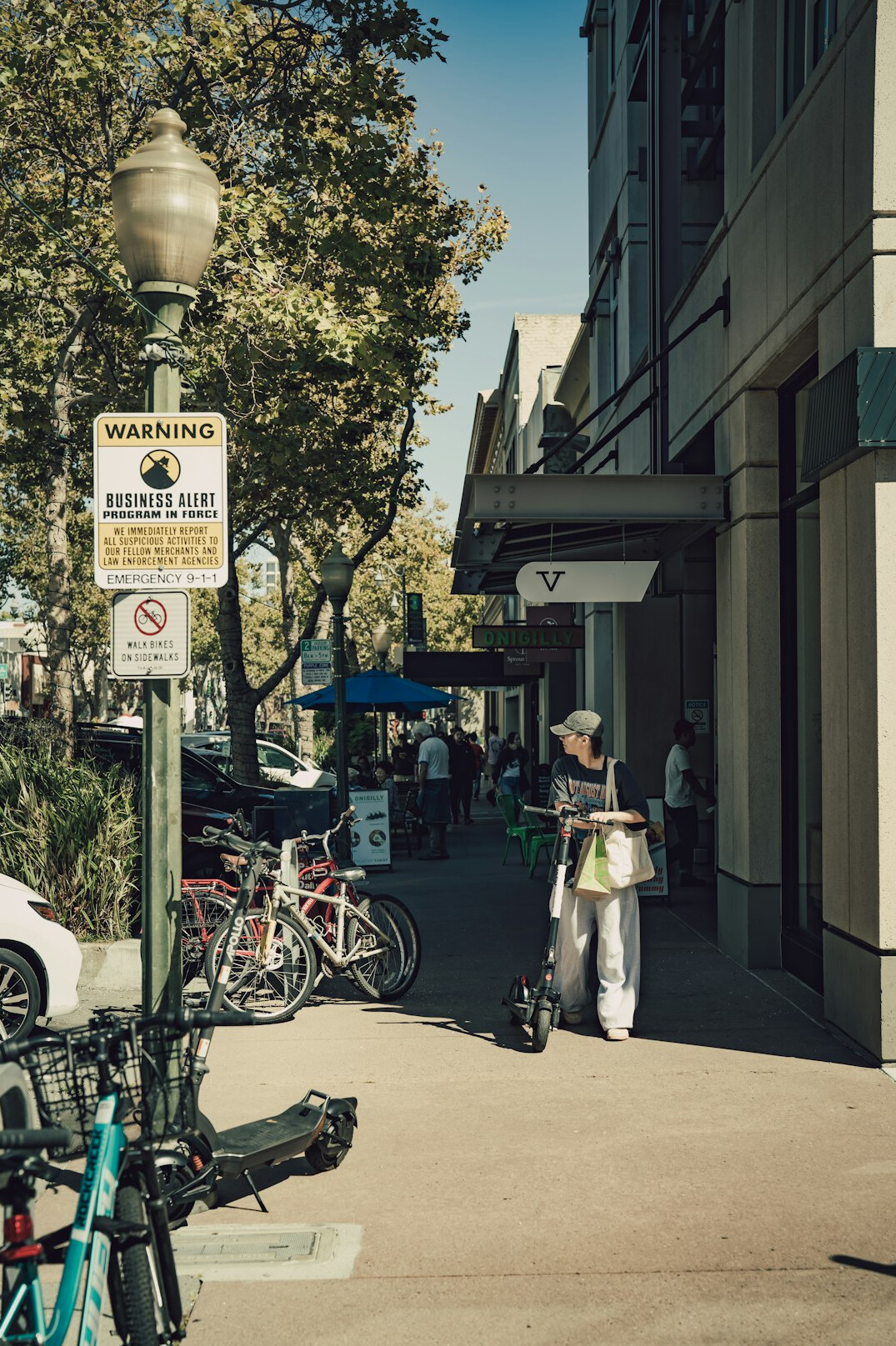 Pedestrians crossing a street and sharing the sidewalk with vendors