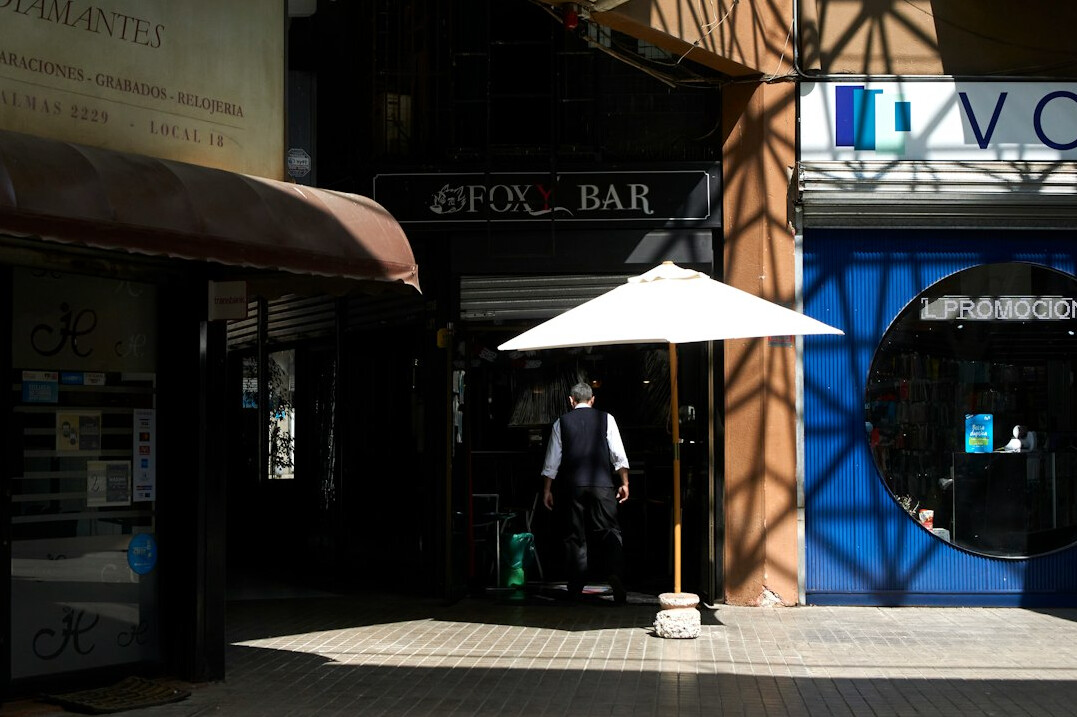 Busy pedestrian street in a Chilean city with people walking between shops