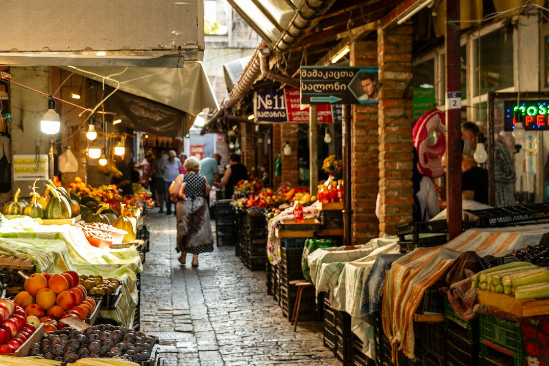 Outdoor street market stalls with fresh produce and shoppers