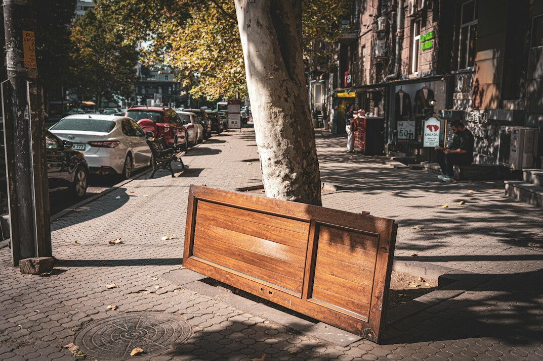 Wooden bench and street sign on an urban sidewalk