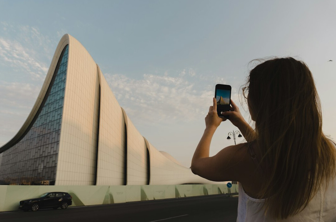 Person taking a photo of a building facade with a mobile phone